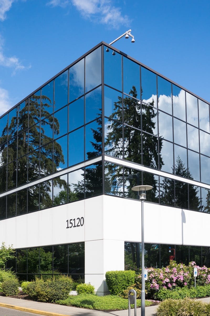 Contemporary office building in Redmond with reflective glass and lush greenery, captured on a sunny day.